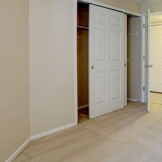 an empty room with white doors and carpet