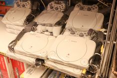 several video game controllers sitting on top of each other in a display case at a store