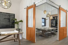 an open door leading to a dining room with a chalkboard on the wall behind it