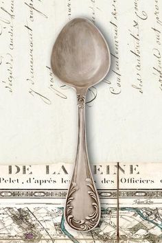 a spoon sitting on top of a piece of paper next to an old fashioned map