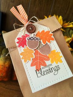 a brown bag with an owl on it and some fall leaves around the tag that says autumn blessing