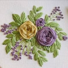 a close up of a embroidery on a piece of cloth with flowers in the center