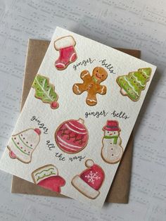 a christmas card with ginger cookies and other holiday decorations on it, sitting on a table