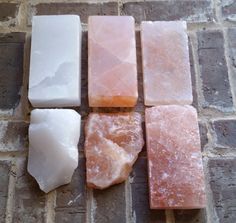 four different types of soap sitting on top of a brick floor