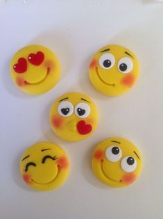 four yellow smiley faces with red noses and hearts on their eyes are arranged in a circle