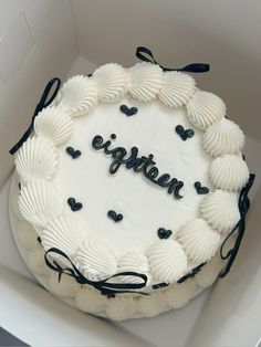 a white cake in a box with black writing on it