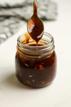 a spoon full of peanut butter on top of a jar