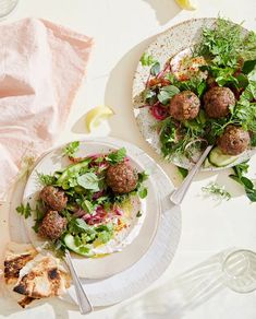 two plates with meatballs and salad on them