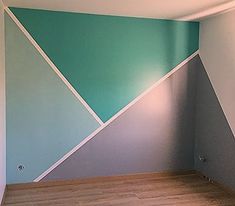 an empty room with blue and green walls