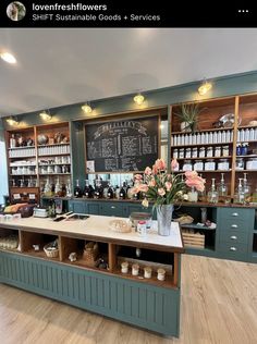 a coffee shop with lots of counter space and flowers in vases on the counter