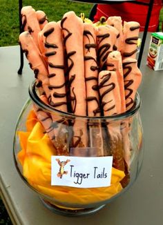 a glass bowl filled with tiger tails on top of a table next to a sign