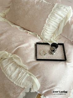 a tray with two rings on it next to a pillow that has been made into a bed