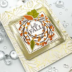 a close up of a card on a table with silver and gold decorations around it