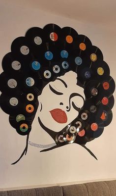 a woman's face painted on the side of a wall with many different colored buttons