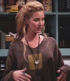 a woman standing in front of a book shelf with a necklace on it's neck