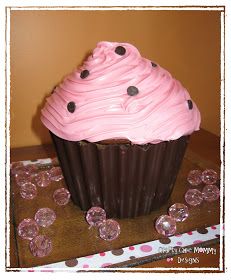 a cupcake with pink frosting and chocolate sprinkles on a table