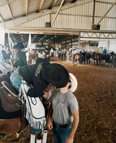 a man standing next to a horse in an arena