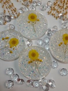 four sunflowers are sitting on top of some crystal balls and chain necklaces