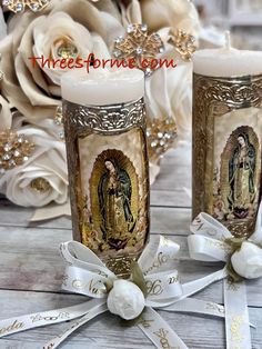 two candles with the image of mary and jesus on them are sitting next to each other