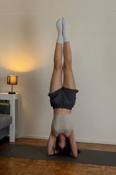 a woman is doing a handstand on her stomach