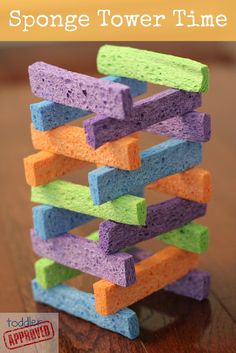 the sponge tower is made out of colored foam blocks and sits on top of a wooden table