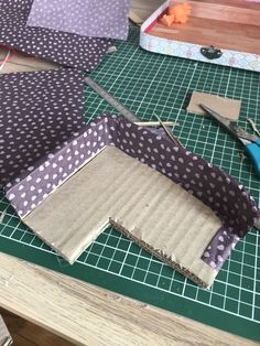 several pieces of fabric sitting on top of a cutting board with scissors and other crafting supplies