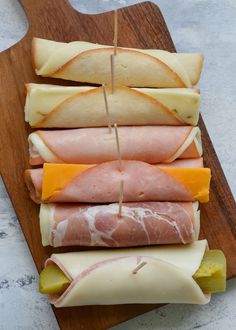 ham, cheese and pickles are arranged on a cutting board