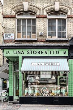 a store front with green tiles and white awnings on the side of it