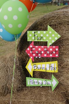 a hay bale filled with lots of balloons next to a sign that says fun begins