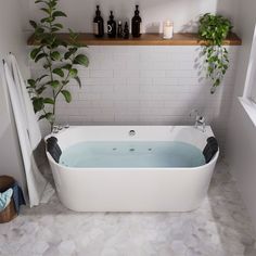 a bathroom with a large white bathtub next to a plant and toiletries on the wall