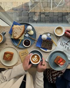 two people sitting at a table with plates of food