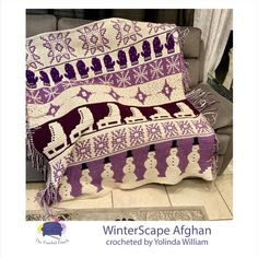 a purple and white afghan sitting on top of a couch