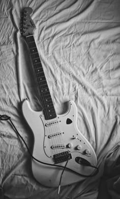 an electric guitar laying on top of a bed