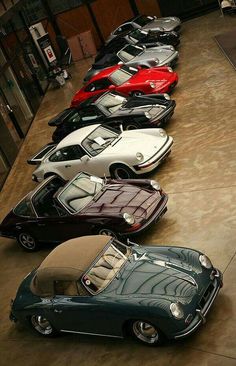 a row of cars parked next to each other on top of a cement floor in a building