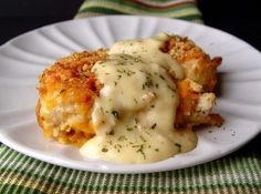 crispy cheddar chicken on a white plate with gravy and parsley