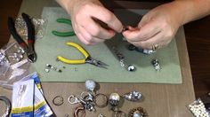 a person working on some jewelry with scissors and other items around them that are sitting on a table