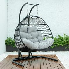 a swing chair with pillows on top of it