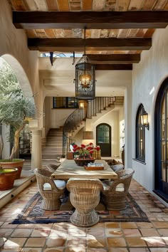 a dining room table and chairs in front of a staircase