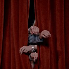 a woman is opening the curtain with her hands