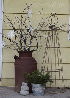 two vases with plants in them next to a windmill on the side of a building