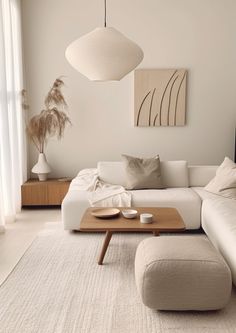 a modern living room with white furniture and neutral colors, including pillows on the couch