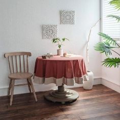 a chair and table with a potted plant on it in front of a window