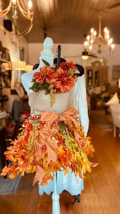 a mannequin is decorated with orange and yellow flowers on it's back