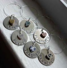 six personalized wine charms sitting on top of a window sill