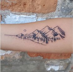 a tattoo on the arm of a person with mountains and trees in the foreground