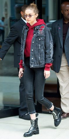 a woman in black and red is walking down the street with her hand on her hip