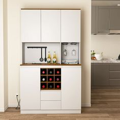 a kitchen with white cabinets and wine bottles on the counter top in front of an oven