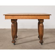 an antique wooden table with two legs and a wood top on casteors is shown