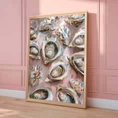 an art piece is displayed in front of a pink wall with seashells on it