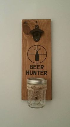 a mason jar hanging on the wall next to a bottle opener with a deer logo